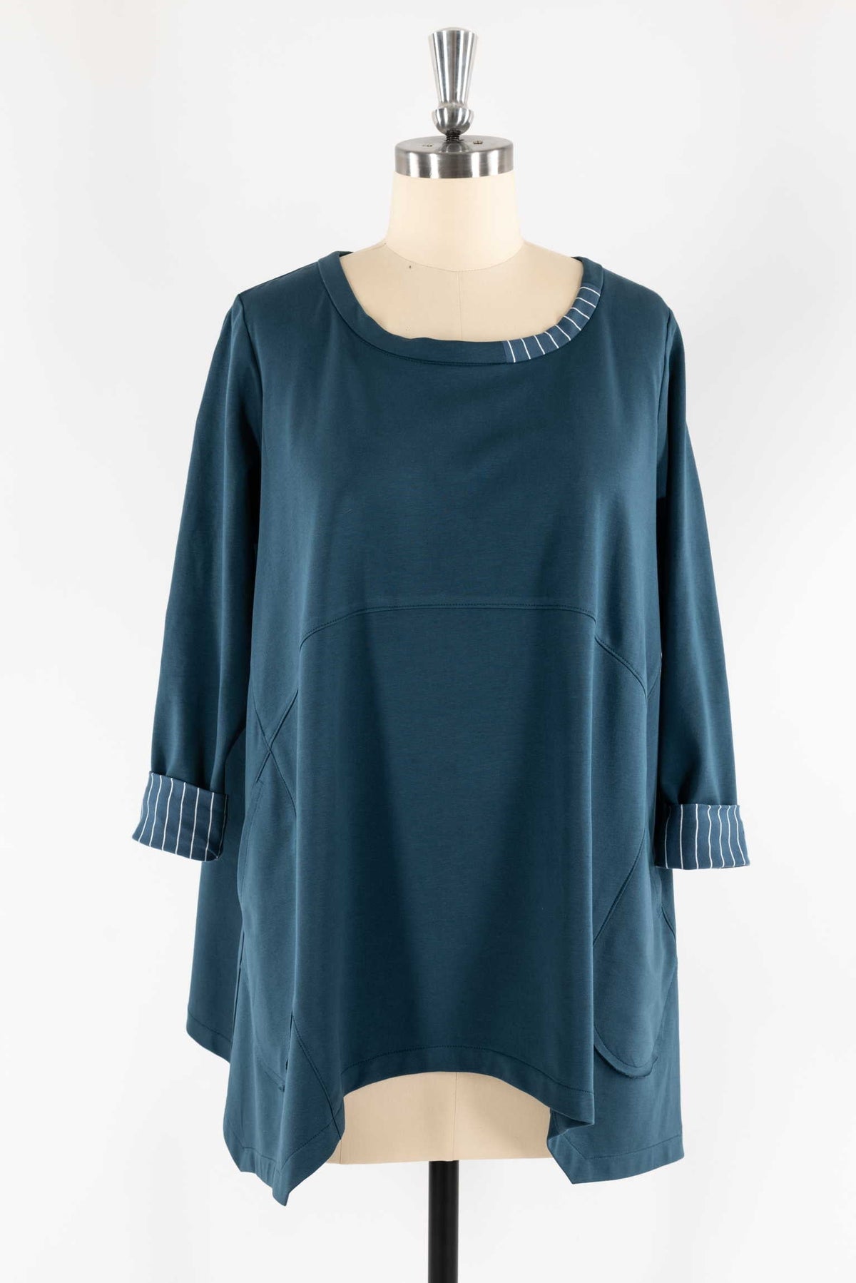 Teal tunic with striped cuffs and neckline, displayed on mannequin for sewing projects