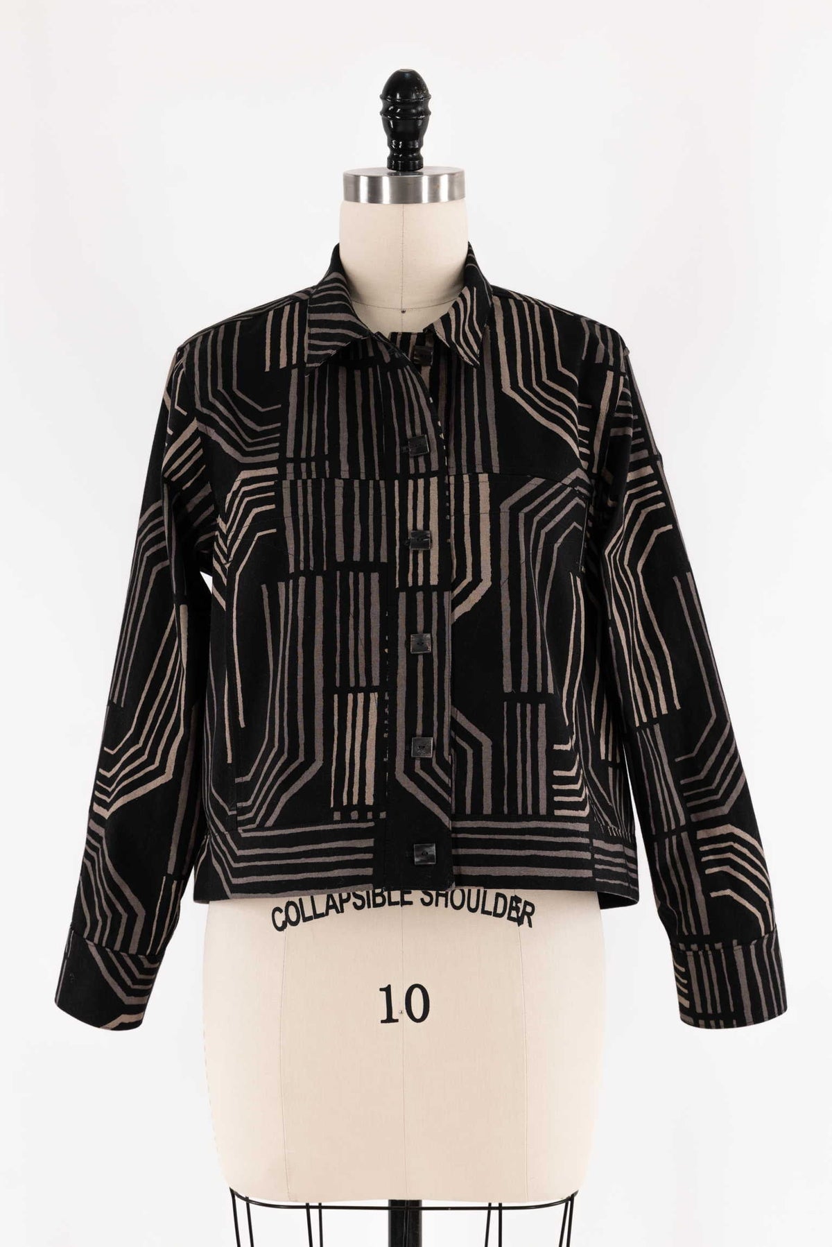 Black and beige geometric print button-up jacket on mannequin, ideal for sewing apparel or fashion projects