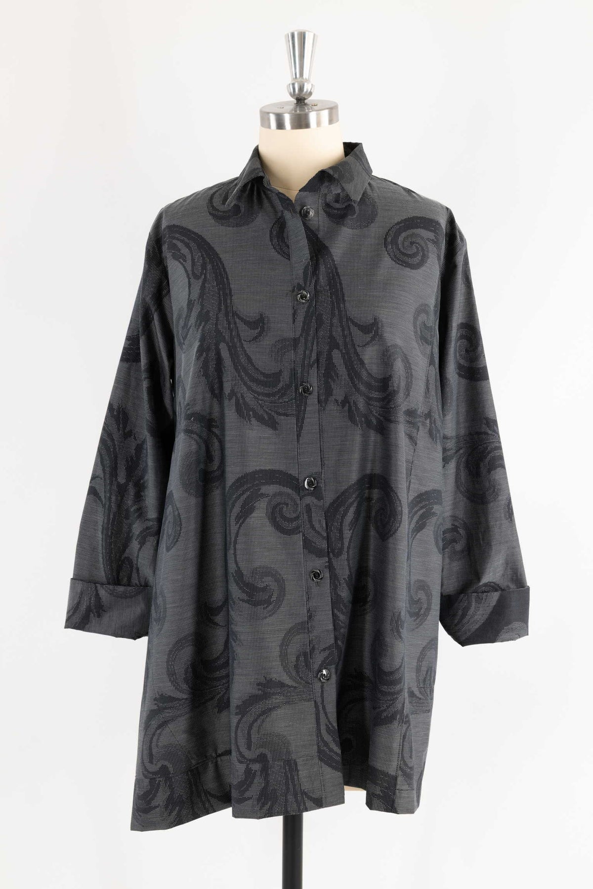 Black patterned button-up shirt with swirl design, displayed on mannequin for sewing projects