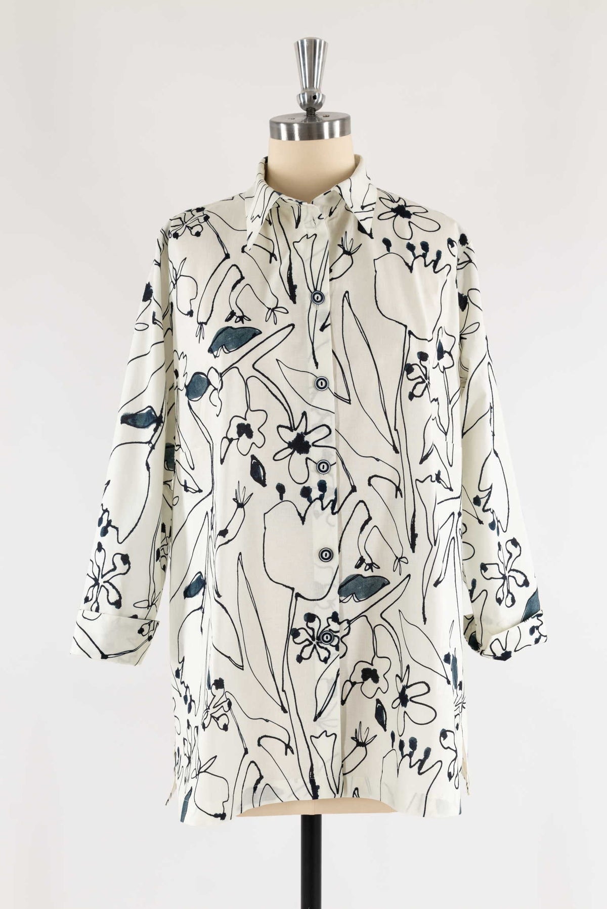 Cream shirt with black and blue floral print, button-front, long sleeves, displayed on mannequin