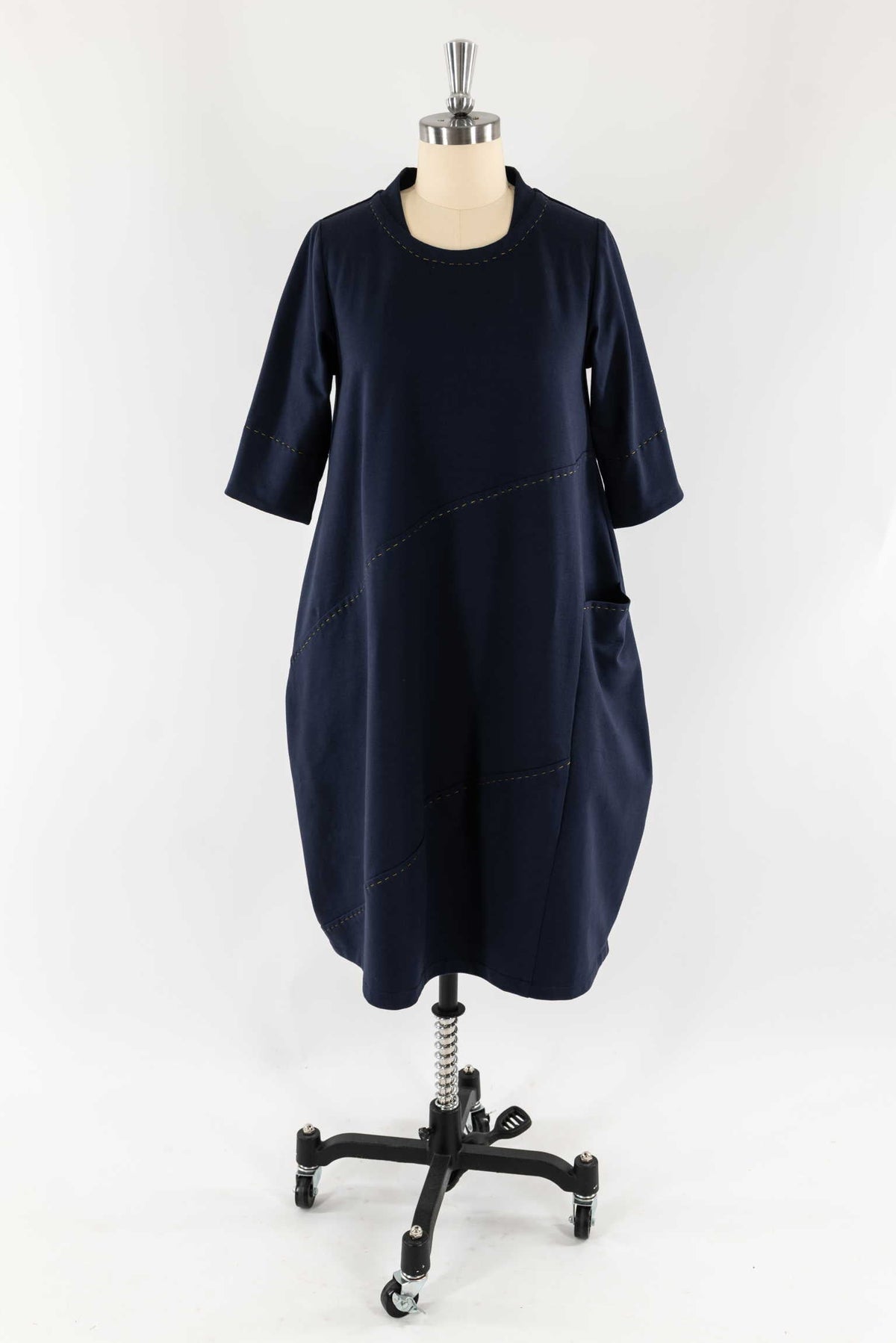 Navy blue knit dress with contrast stitching, pockets, and 3/4 sleeves on mannequin