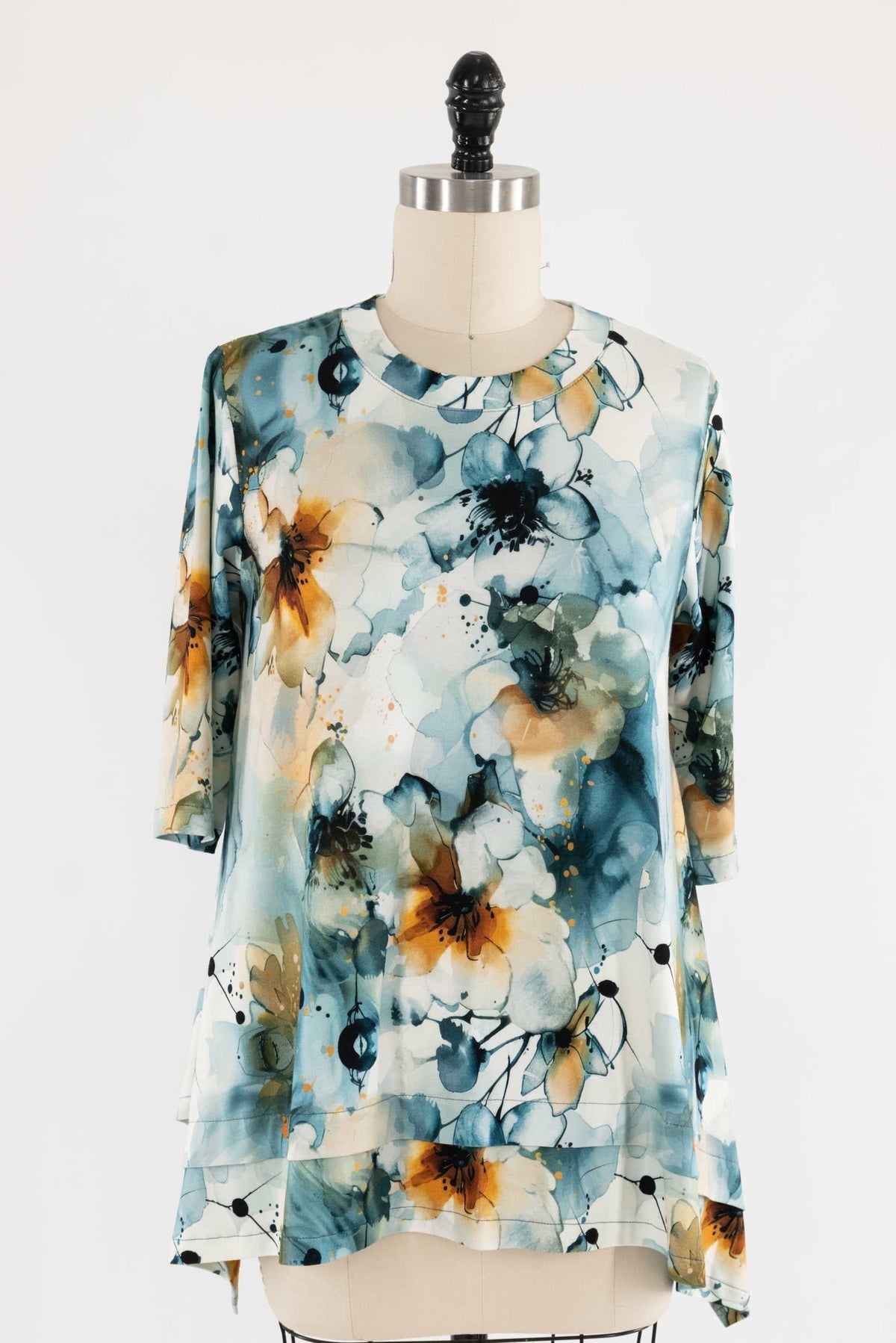 Watercolor floral print fabric top with blue, orange, and white hues on mannequin