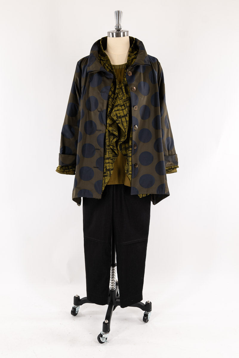 Olive green polka dot jacket with ruffled blouse and black pants on mannequin for sewing projects