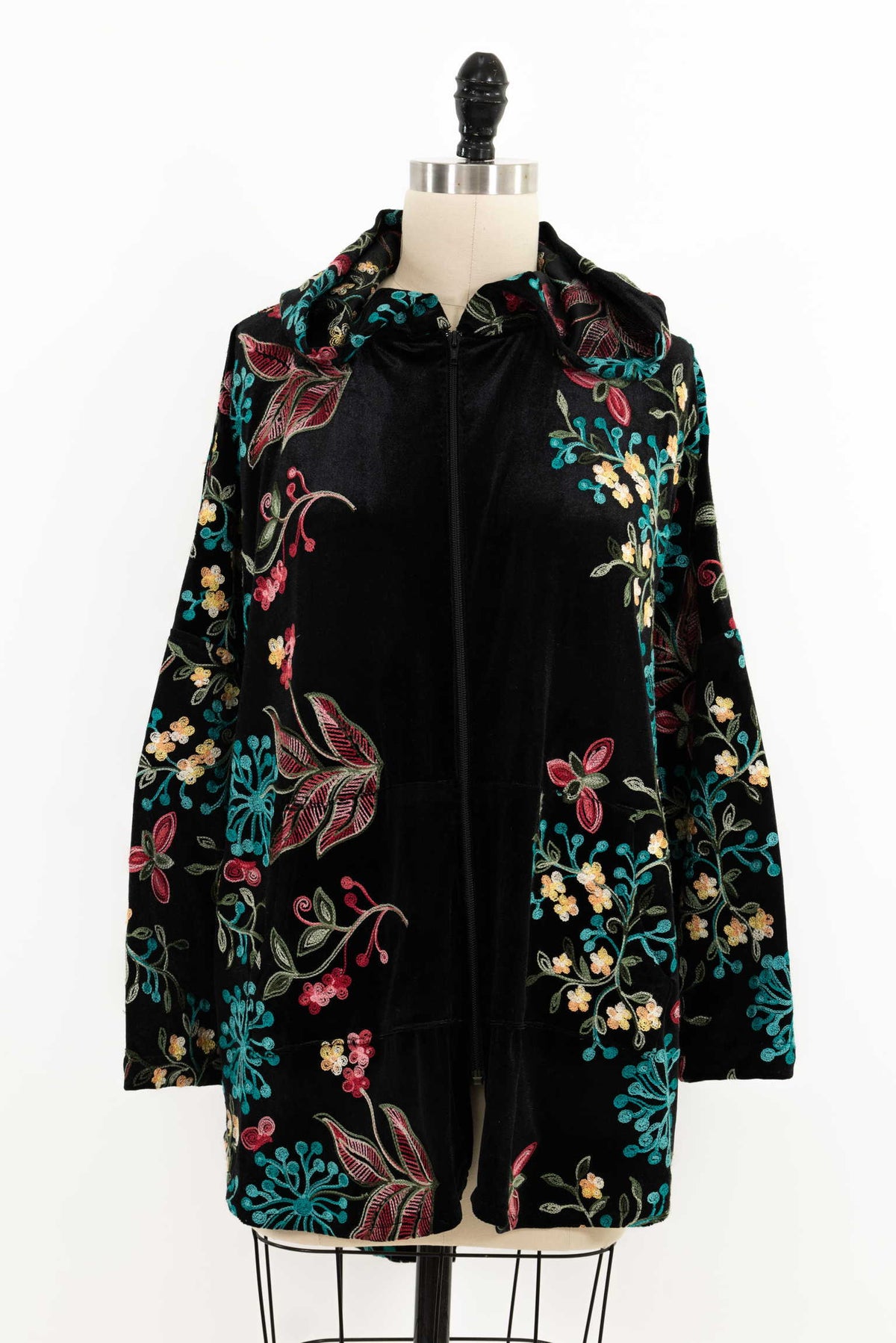 Black velvet hooded jacket with colorful floral embroidery, perfect for sewing apparel or quilting projects.
