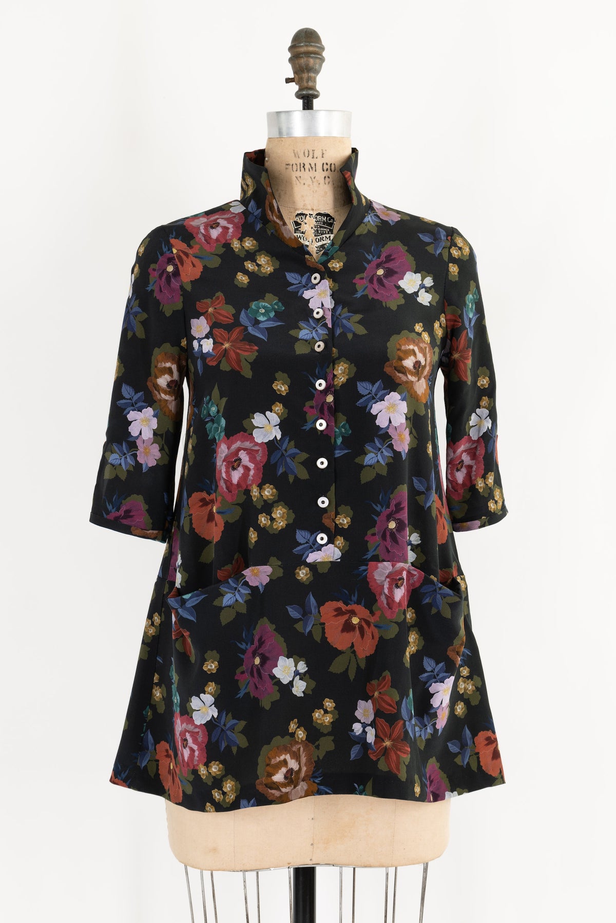 Floral print dress with button front, 3/4 sleeves, and pockets on mannequin — ideal for sewing projects