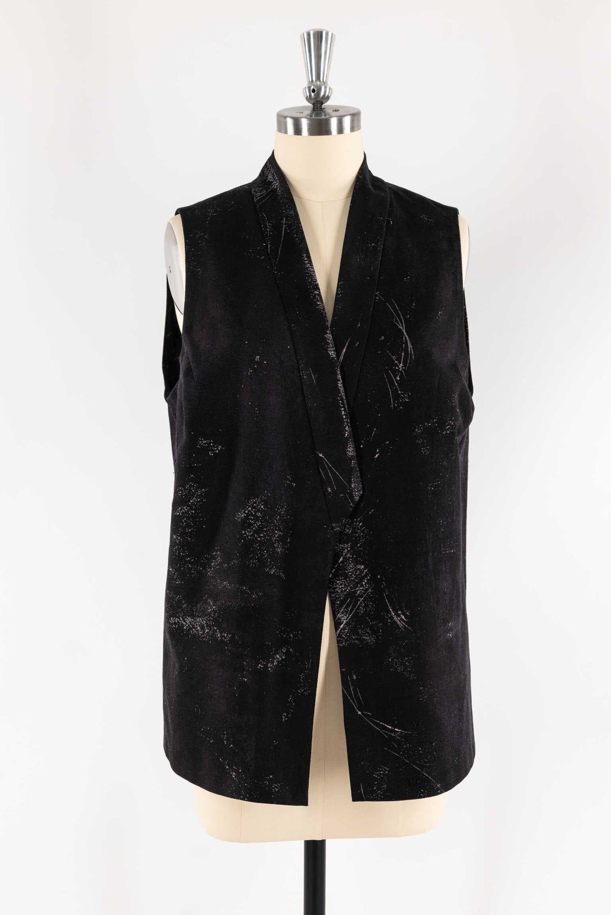 Black textured sleeveless vest with abstract white speckles on mannequin