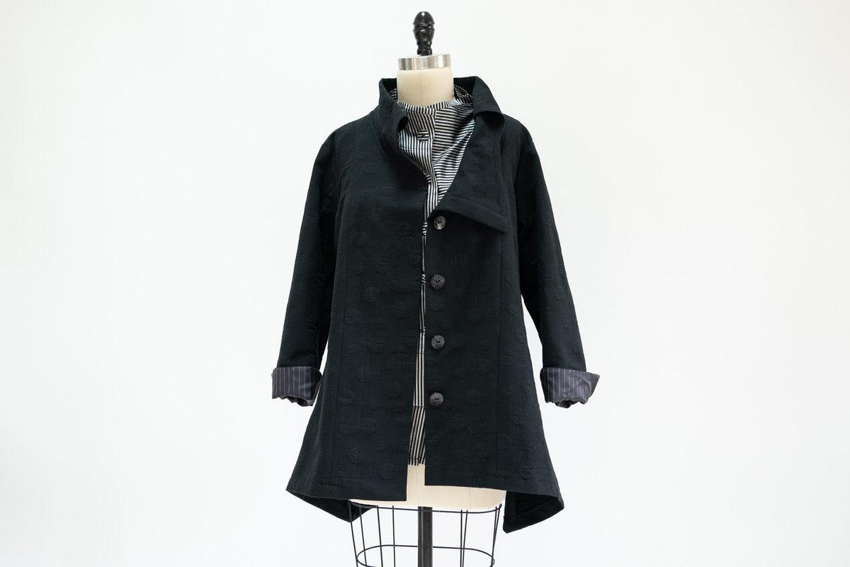 Black textured button-up coat with striped lining on mannequin, ideal for sewing apparel projects