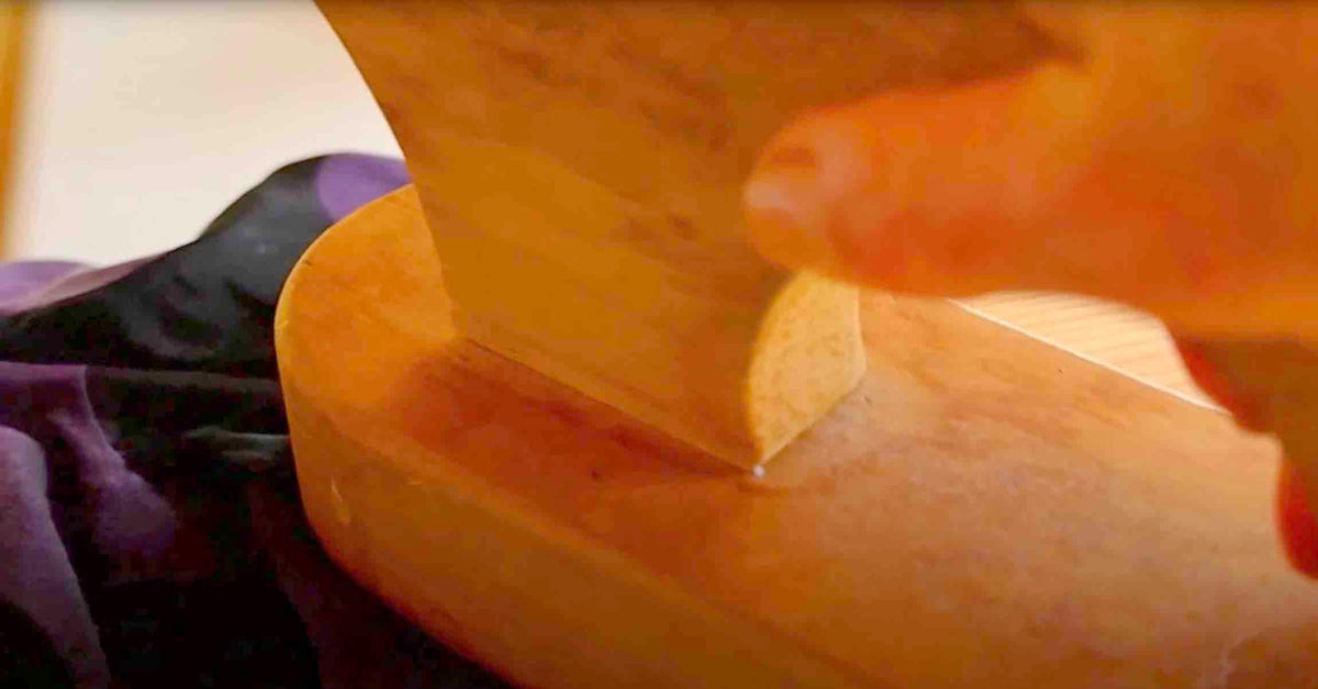 Hand smoothing rich purple fabric on wooden surface, ideal for sewing projects and apparel crafting