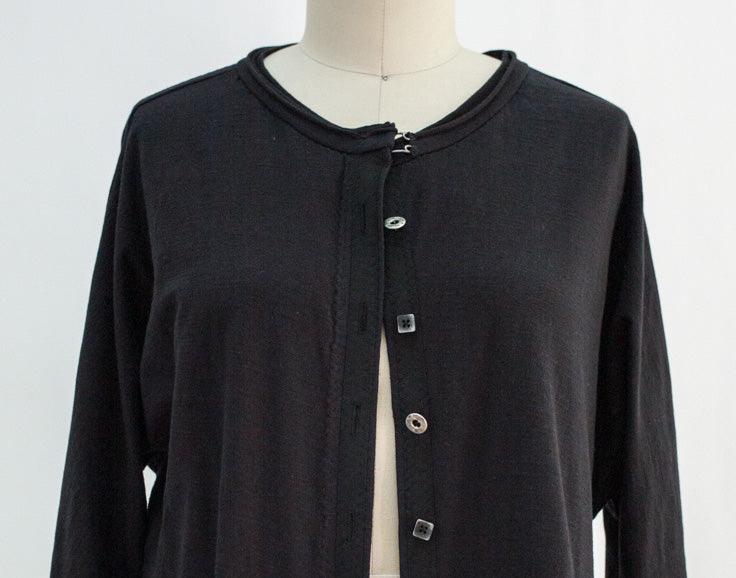 Black button-up knit top with round neckline, ideal for sewing apparel and fashion projects