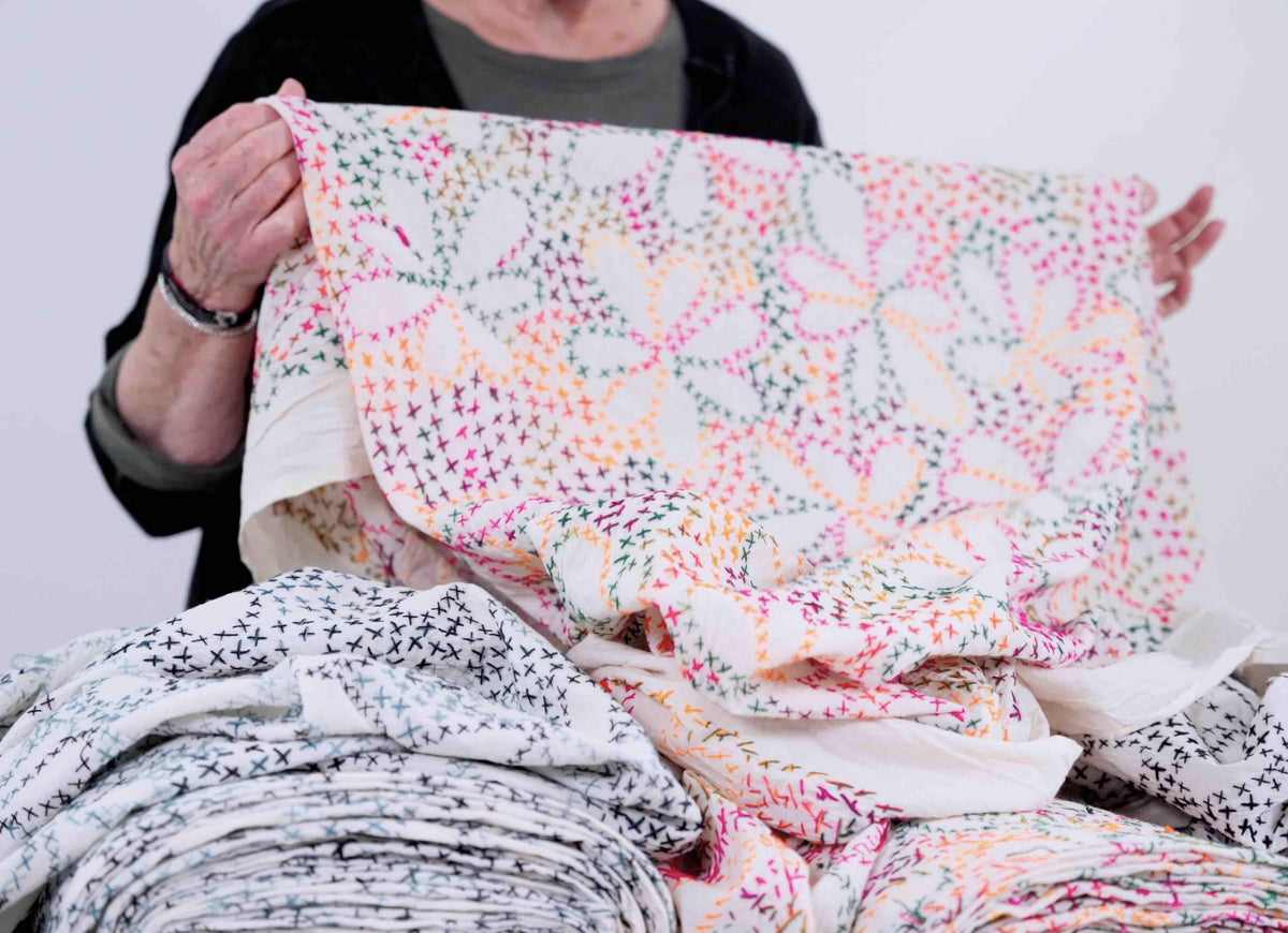 Colorful cross-stitch patterned fabric by the yard, ideal for apparel and quilting projects