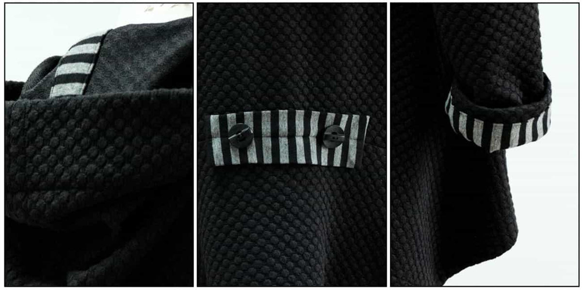 Black textured fabric with striped contrast cuffs and button details, ideal for apparel sewing projects.