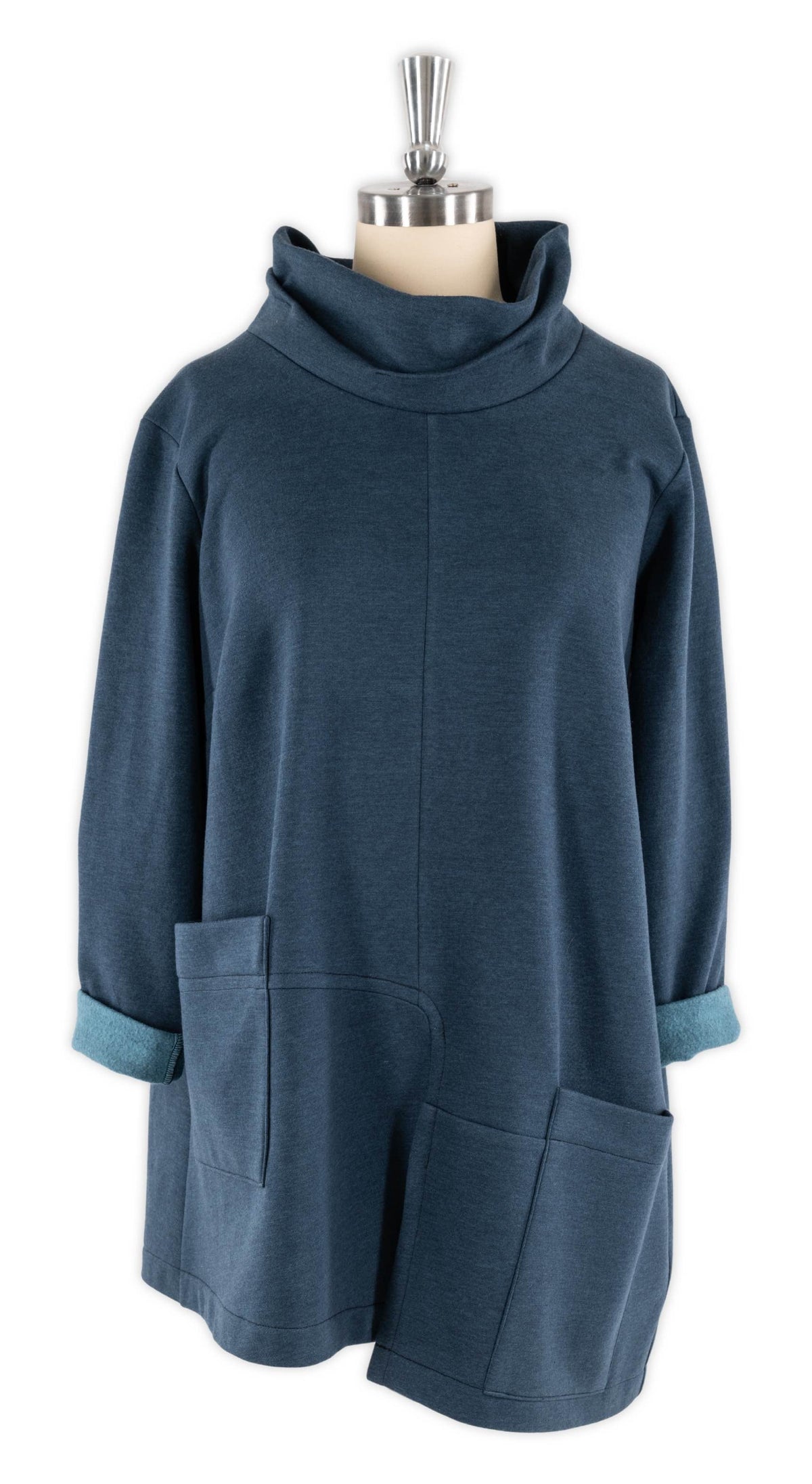 Blue knit tunic with cowl neck, rolled sleeves, and front pockets on mannequin