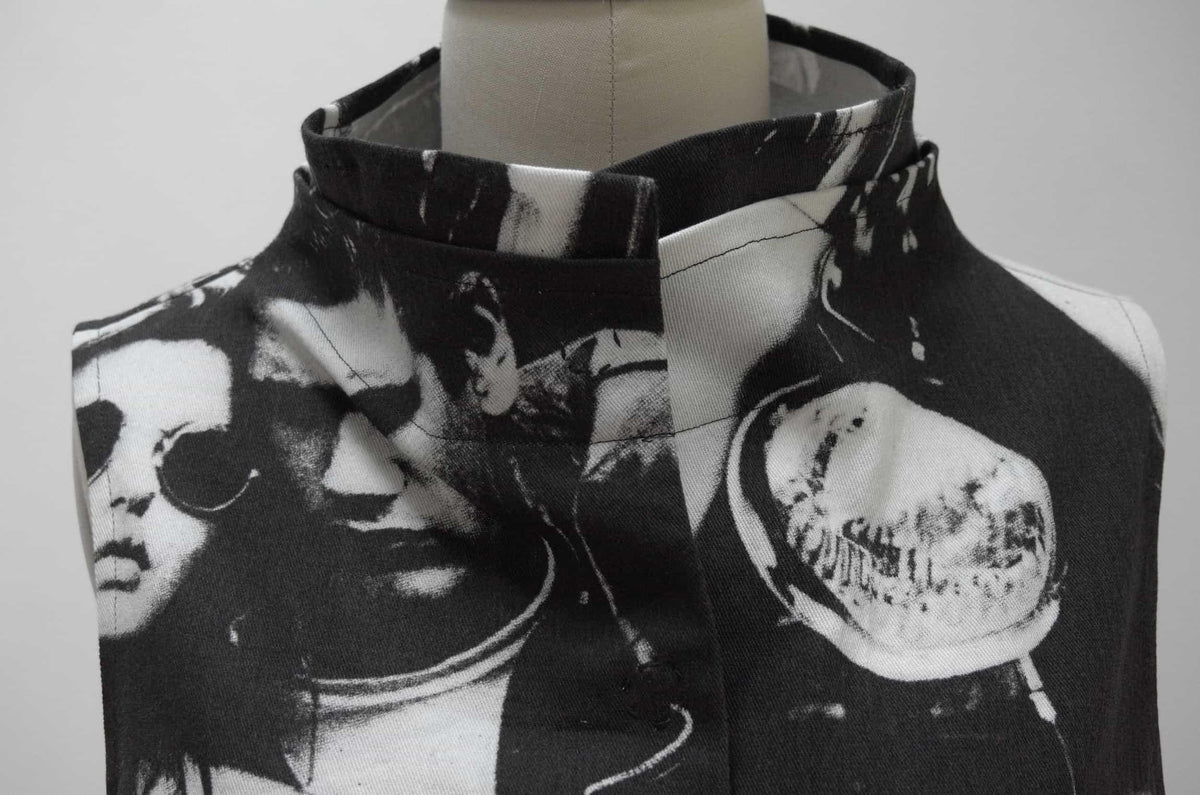 Black and white printed fabric with bold graphic faces, ideal for fashion sewing projects.