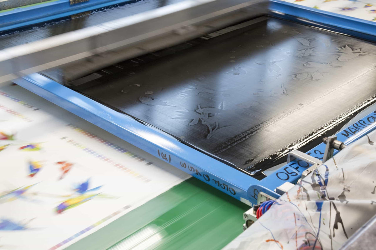 Fabric printing machine applying colorful floral patterns to textile roll for apparel and quilting
