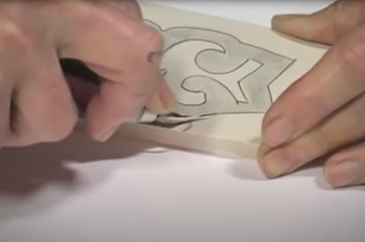 Hands tracing a sewing pattern on fabric for apparel design