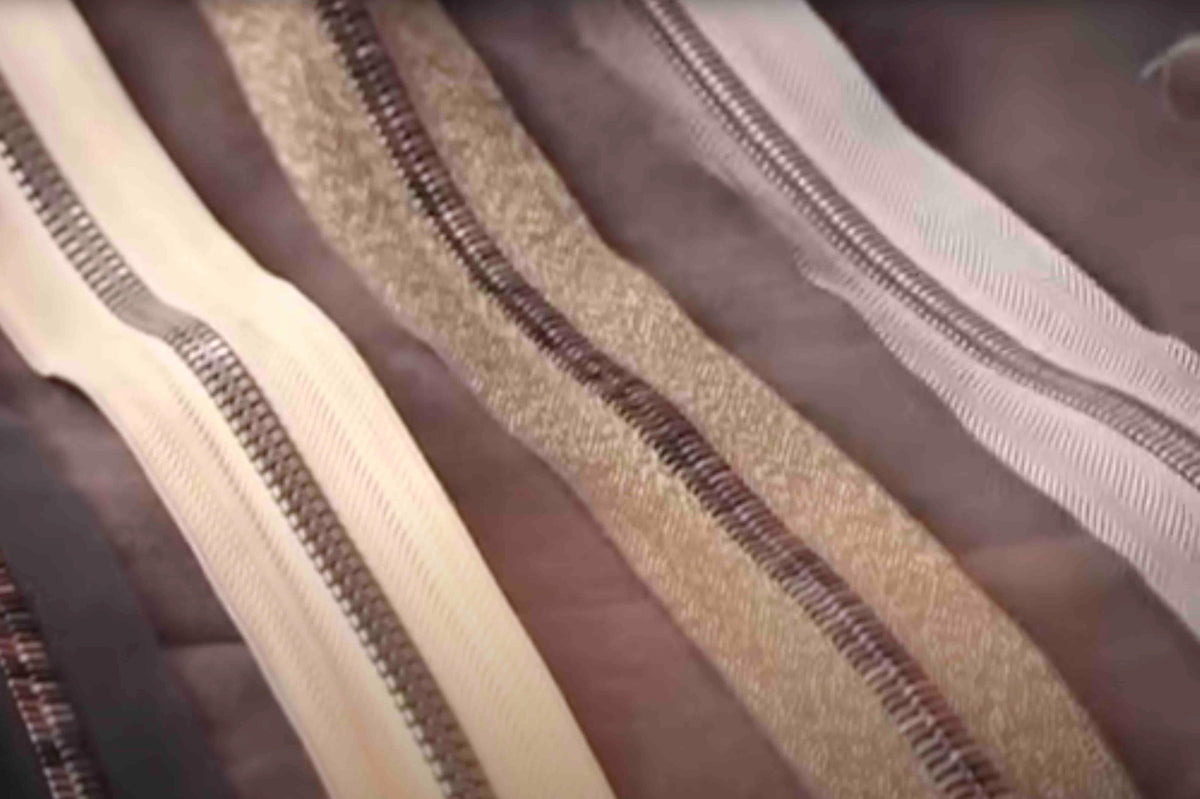 Assorted fabric zippers in neutral tones for sewing and apparel projects