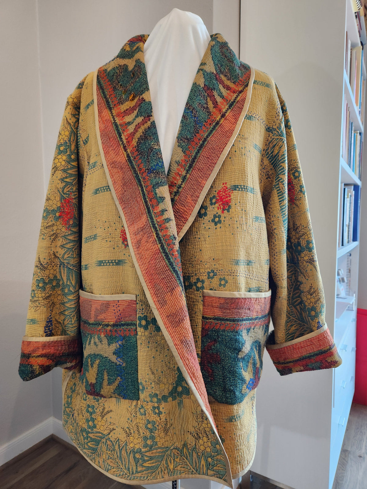 Floral patterned kimono jacket with colorful trim, displayed on mannequin for sewing and fashion projects