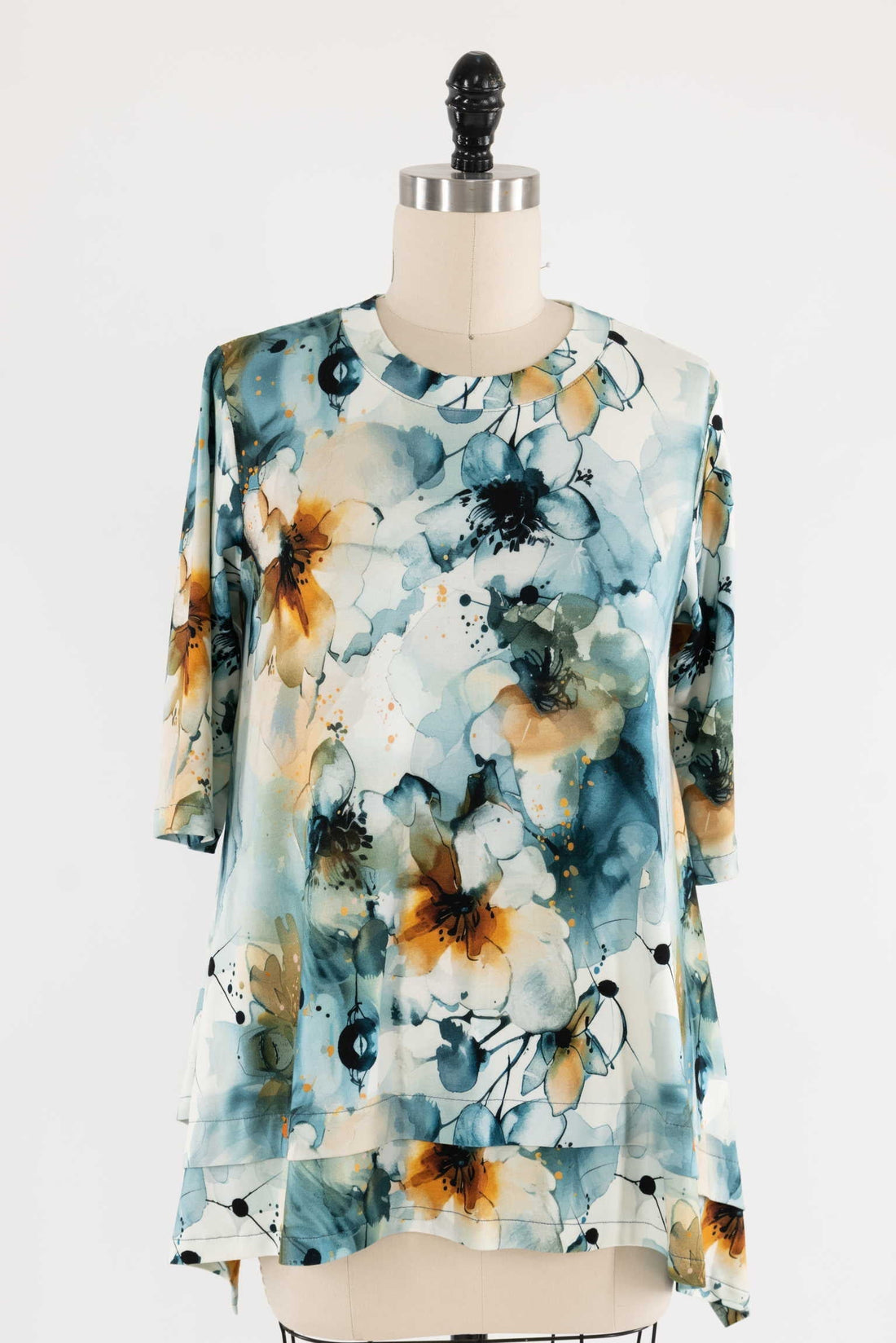 Watercolor floral print fabric top with blue, orange, and white hues on mannequin