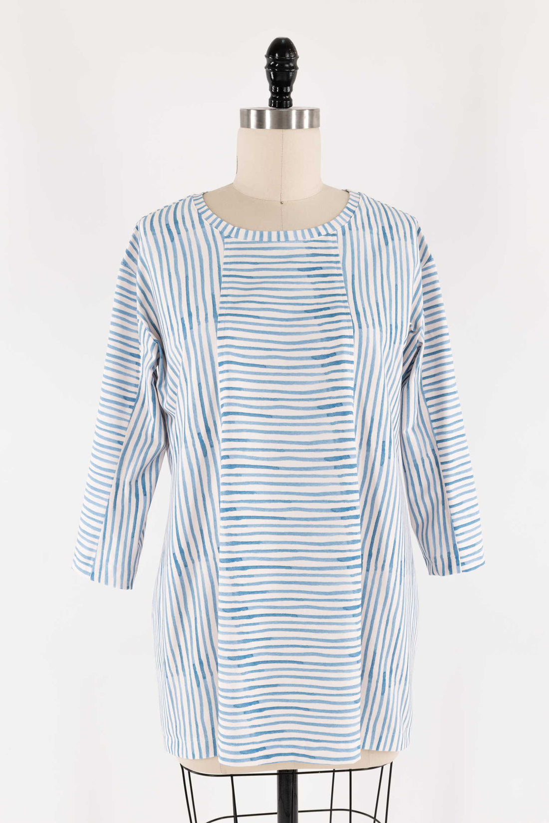 Blue and white striped tunic dress on mannequin, ideal for sewing projects with cotton or linen fabric