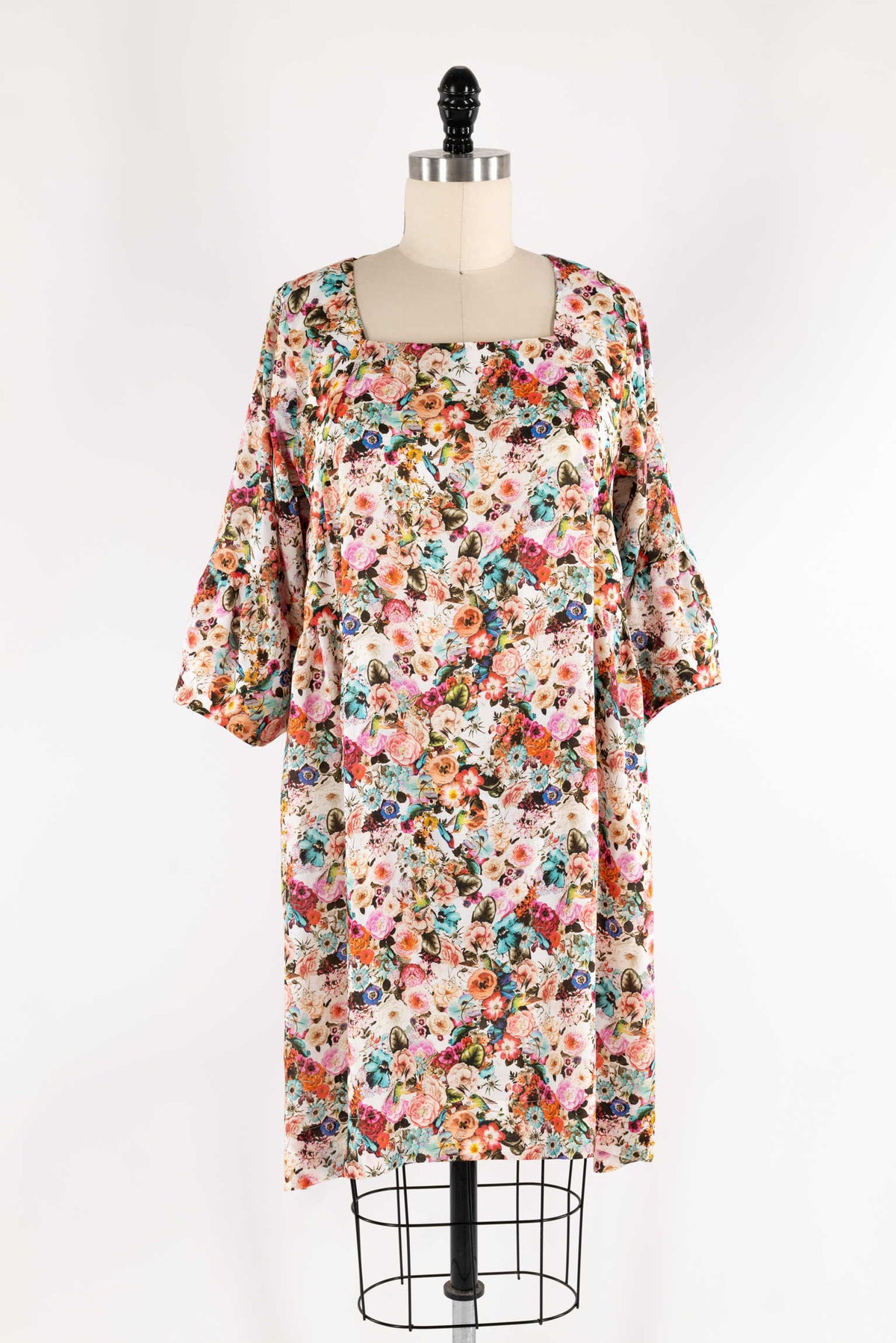 Floral print dress with bell sleeves on mannequin, ideal for sewing projects