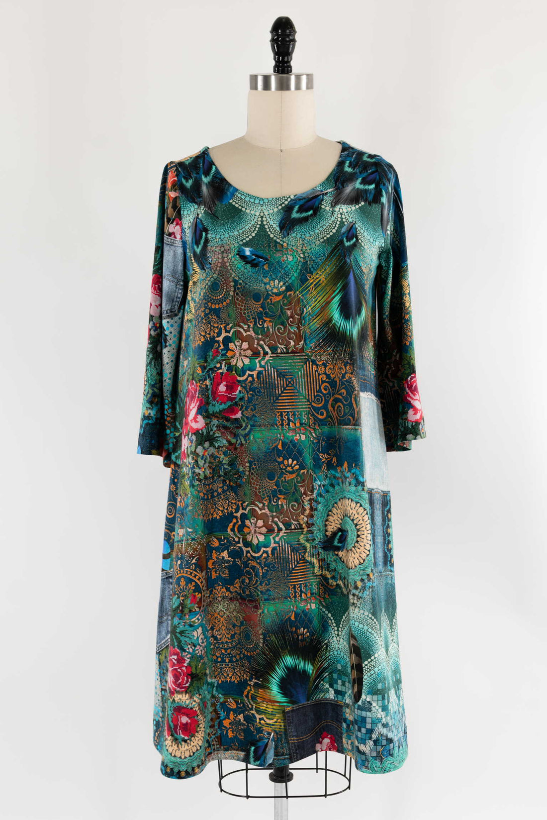 Boho patchwork dress with peacock feathers, florals, and denim accents on mannequin