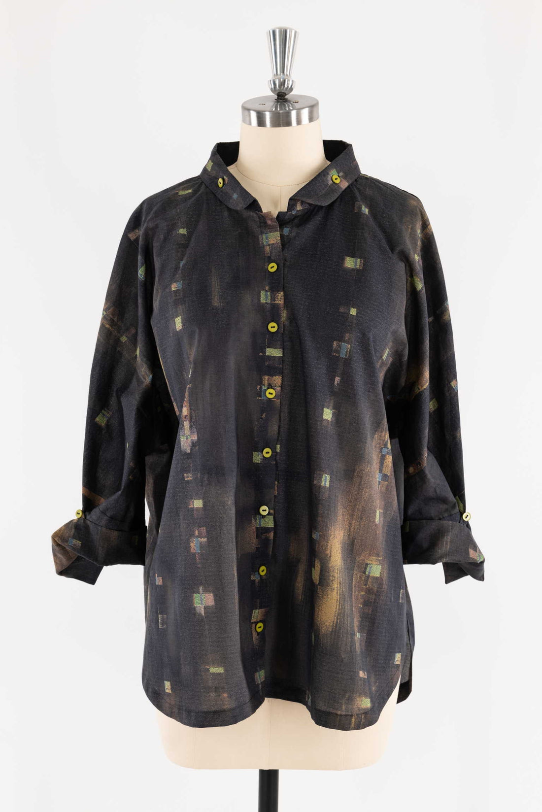 Abstract patterned button-up shirt with yellow buttons on mannequin