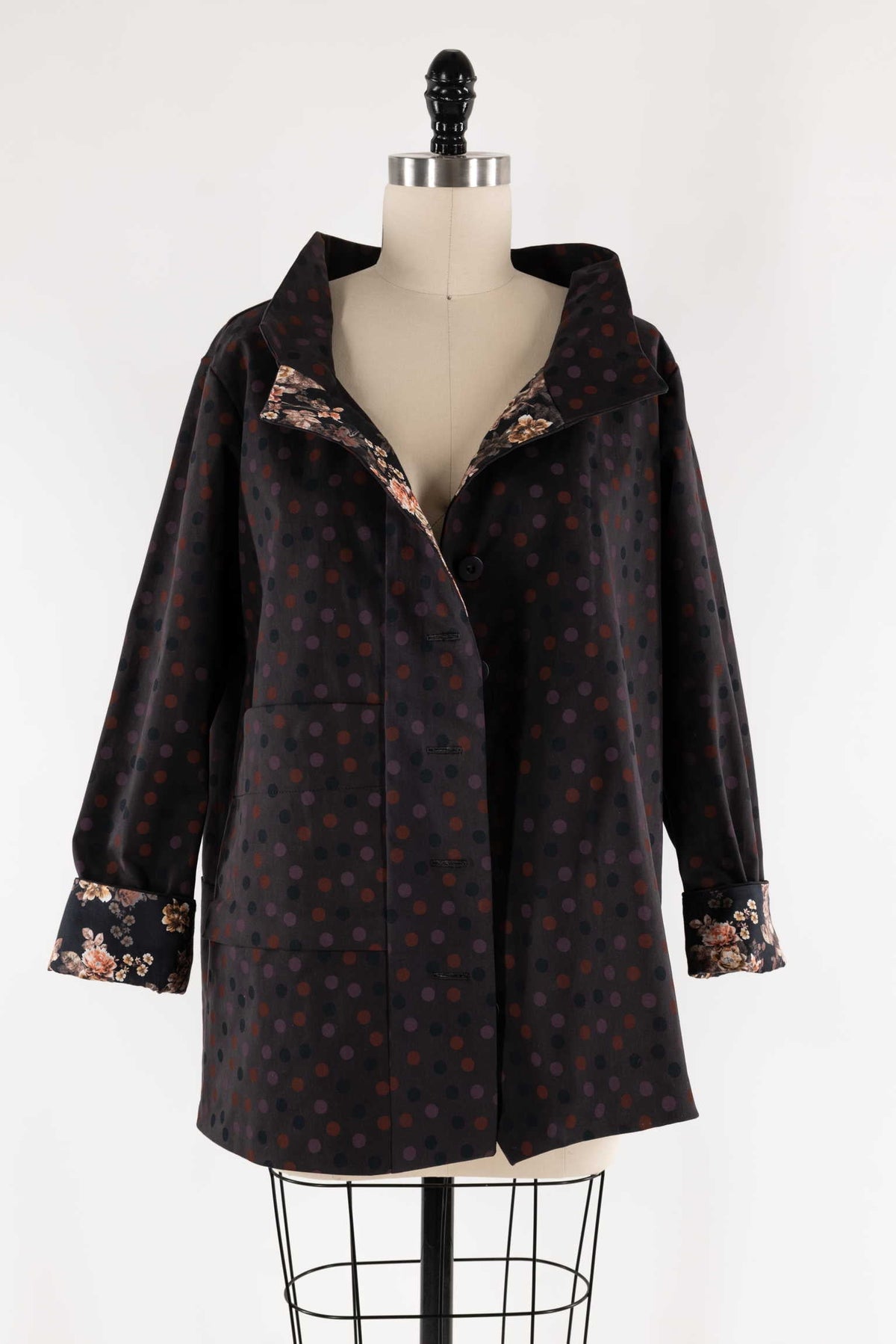 Polka dot coat with floral lining on mannequin, ideal for sewing apparel and fashion projects