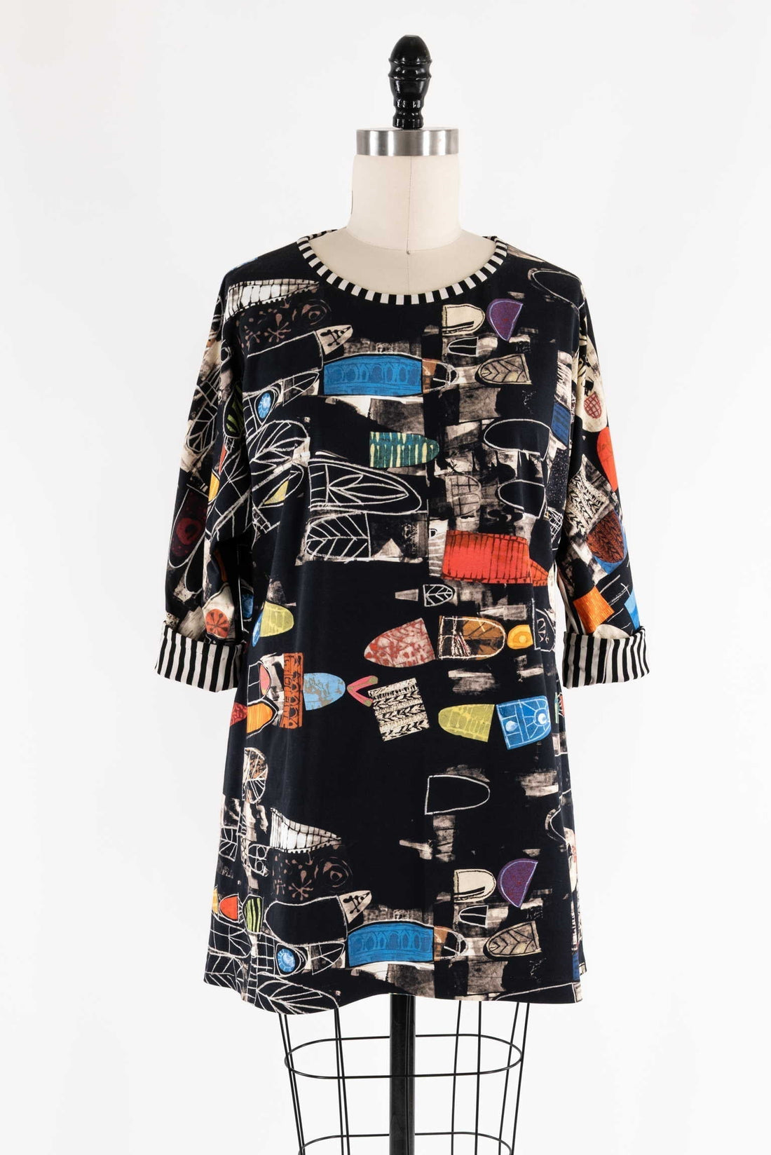 Abstract print dress with geometric shapes and striped cuffs on mannequin, ideal for creative sewing projects