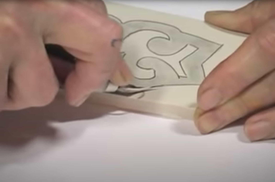 Hands tracing a sewing pattern on fabric for apparel design