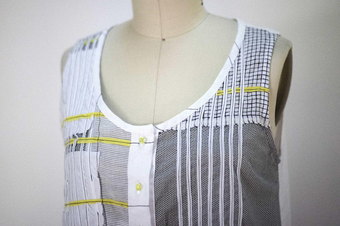 Sleeveless patchwork top with striped, checkered, and mesh panels, yellow accents, and button front
