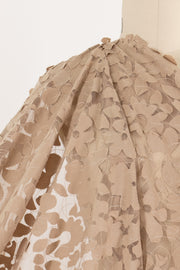Beige floral lace fabric with leaf cutouts, ideal for apparel and creative sewing projects