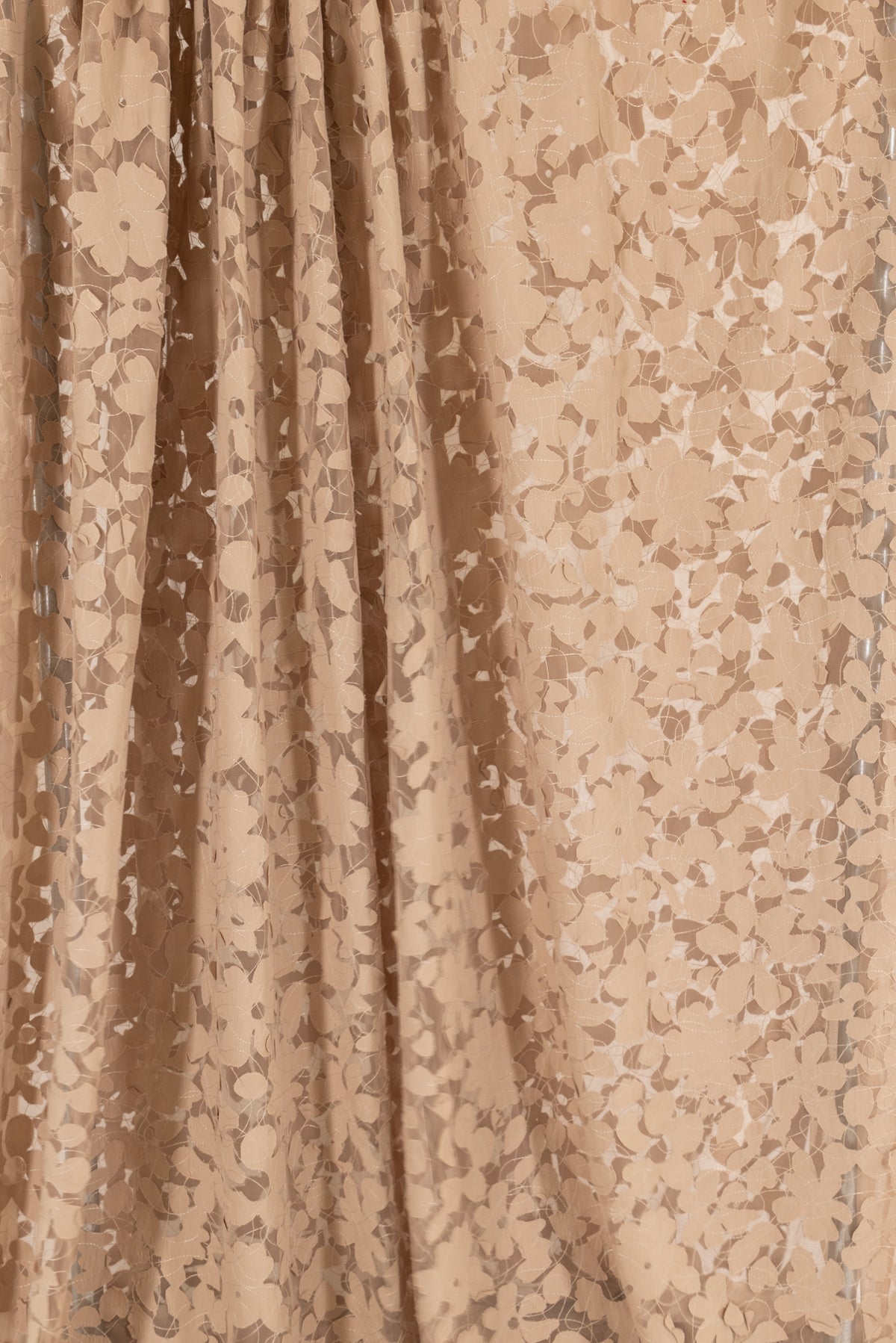 Tan floral print fabric with sheer texture, ideal for apparel and creative sewing projects