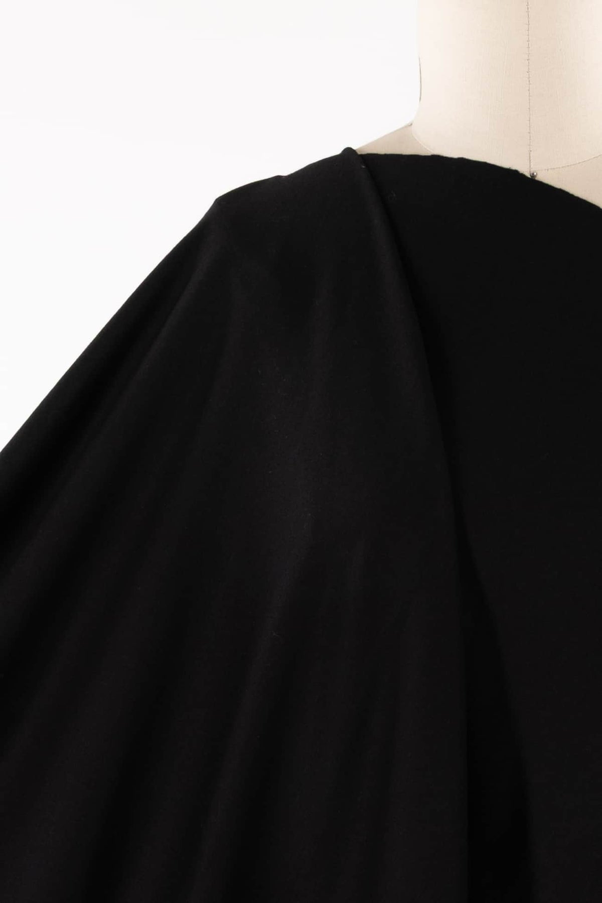 Black solid fabric draped on mannequin, ideal for apparel sewing and fashion projects