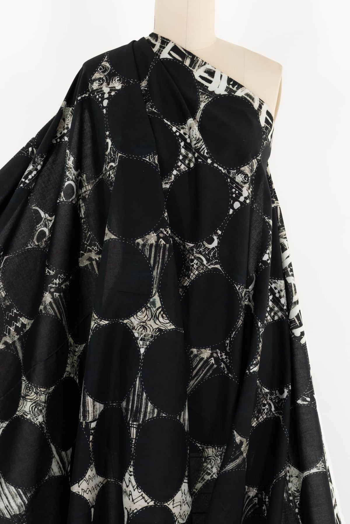 Black and white abstract geometric print fabric draped on mannequin, ideal for fashion sewing projects
