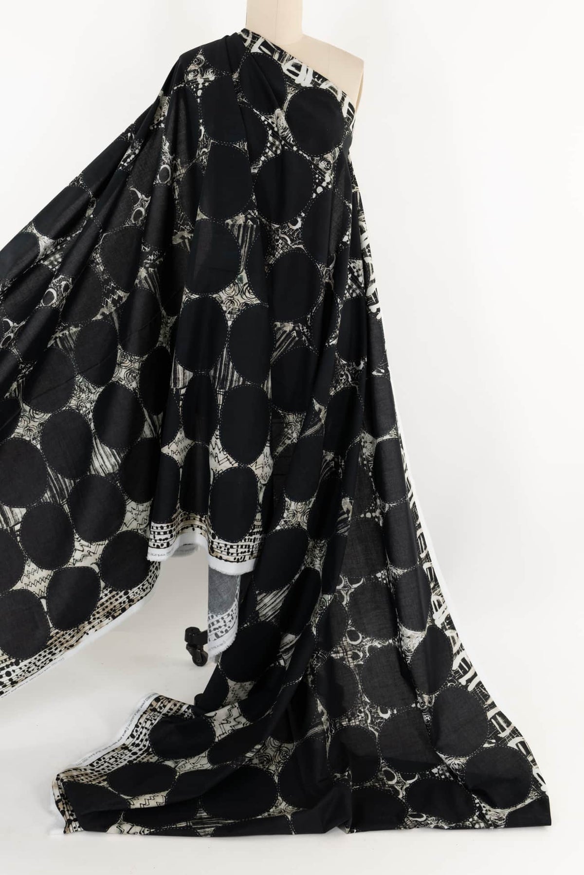 Black and white abstract geometric fabric with bold circles, ideal for fashion sewing projects.