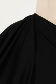 Black solid fabric draped on mannequin, ideal for apparel sewing and fashion projects