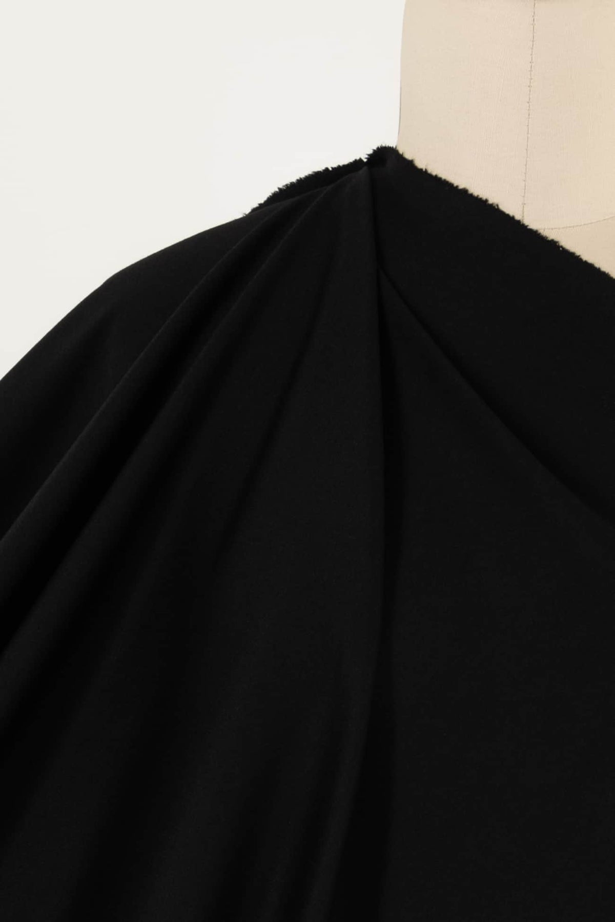 Black solid fabric draped on mannequin, ideal for apparel sewing and fashion projects