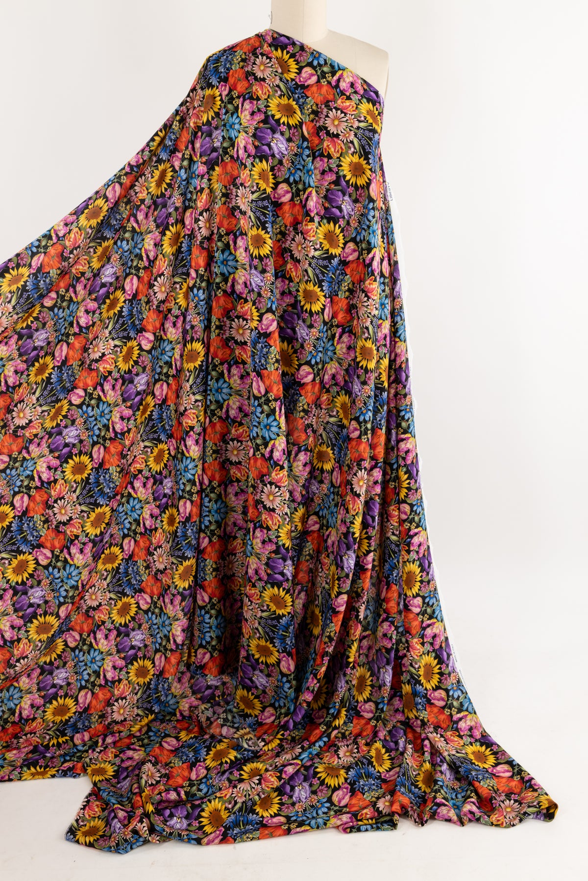 Vibrant floral print fabric with sunflowers, roses, and daisies on dark background, ideal for apparel and quilting projects.