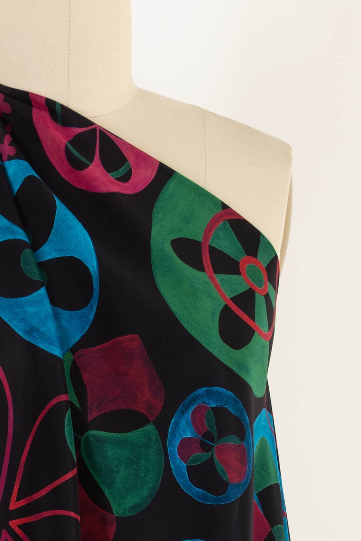Vibrant abstract floral print fabric in teal, green, red on black — ideal for apparel sewing projects