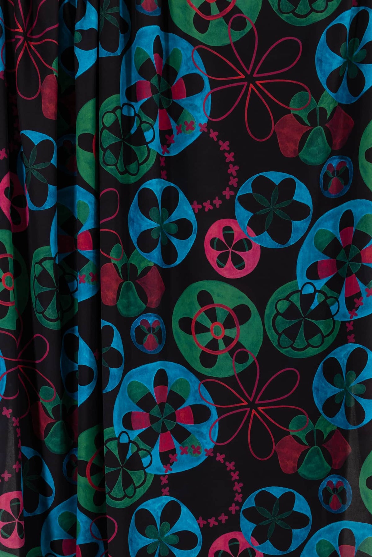 Vibrant floral print fabric in teal, green, pink on black — ideal for apparel and creative sewing projects.