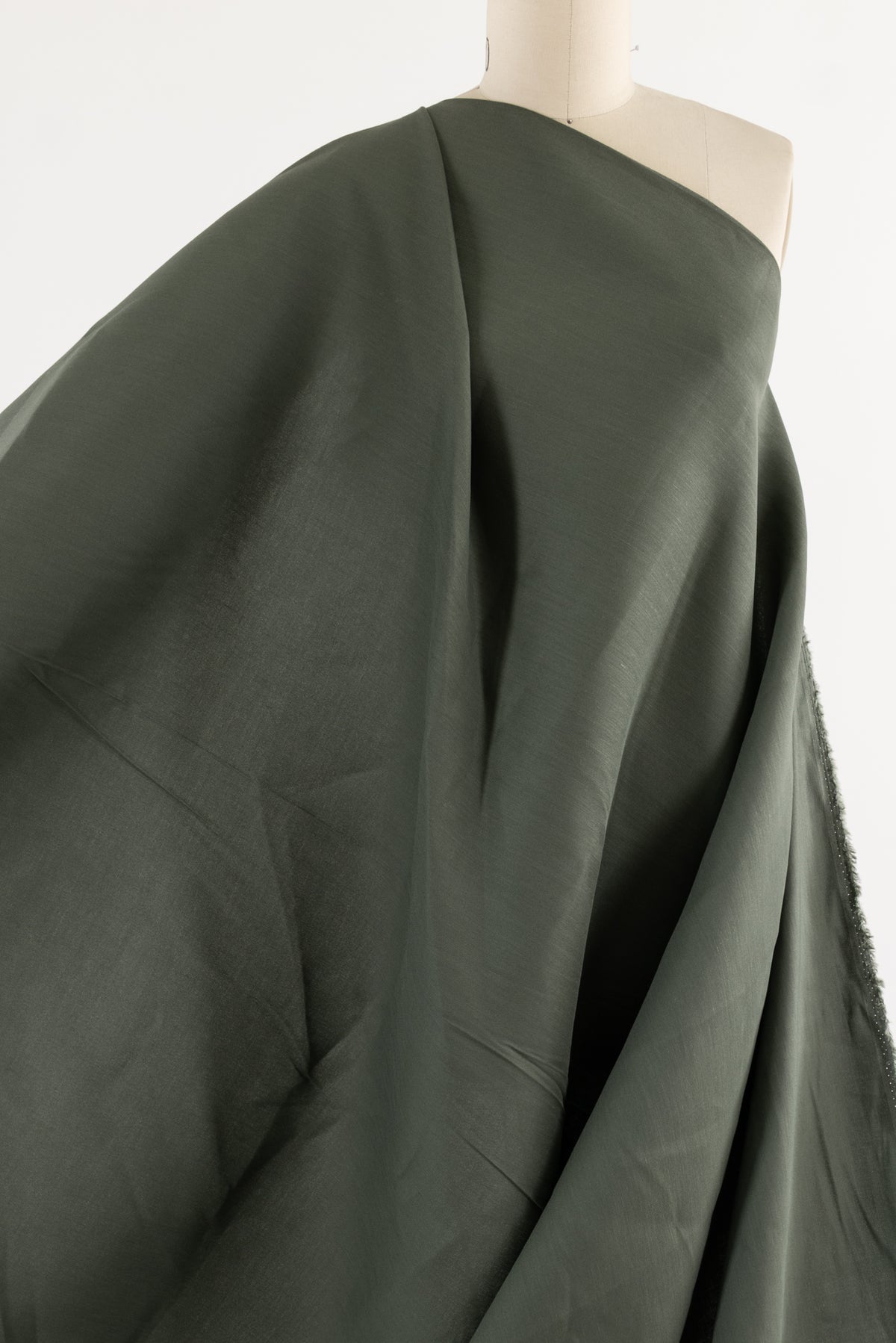 Olive green woven fabric draped on mannequin, ideal for apparel sewing and fashion projects