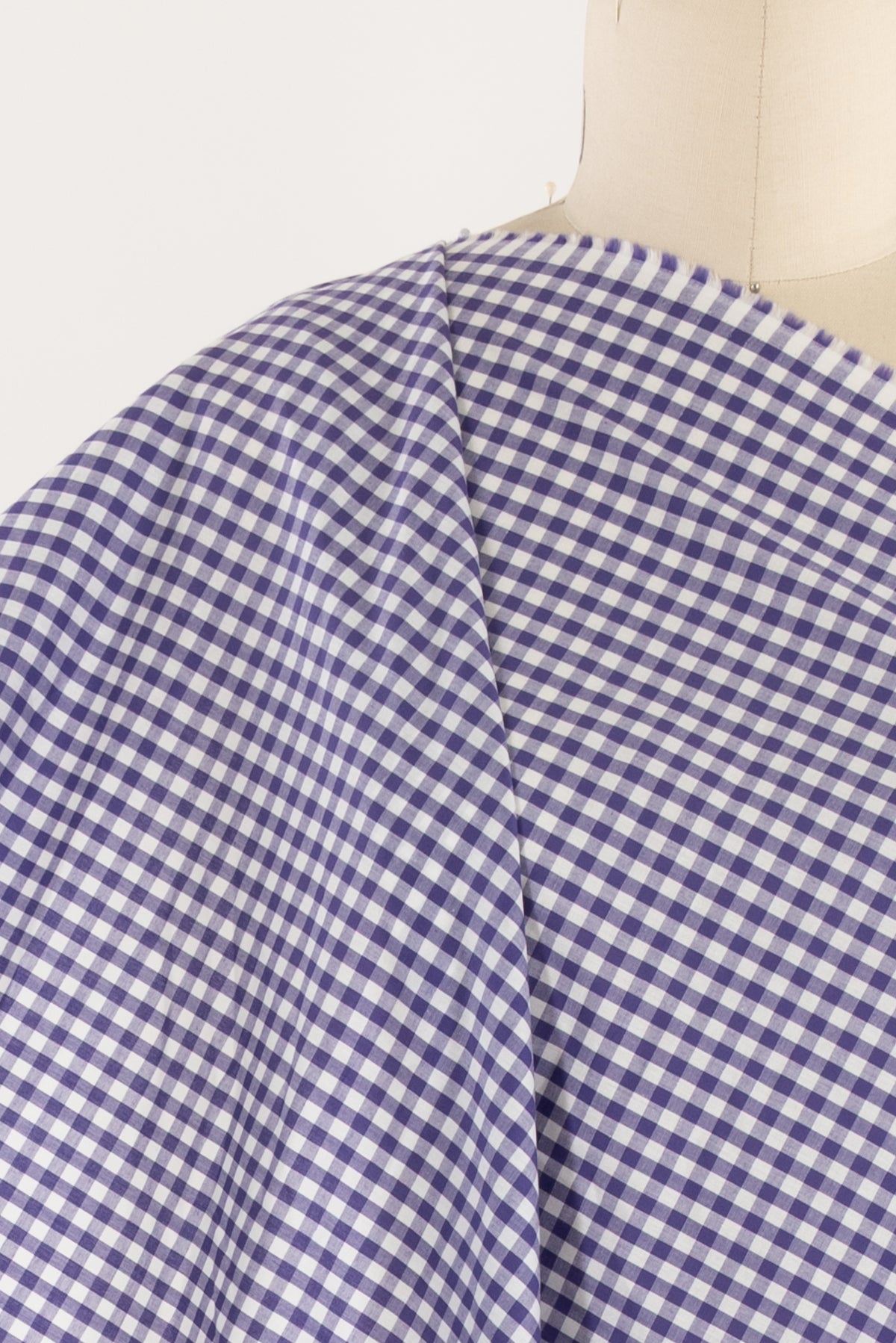 Purple and white gingham check fabric draped on mannequin, ideal for apparel sewing projects