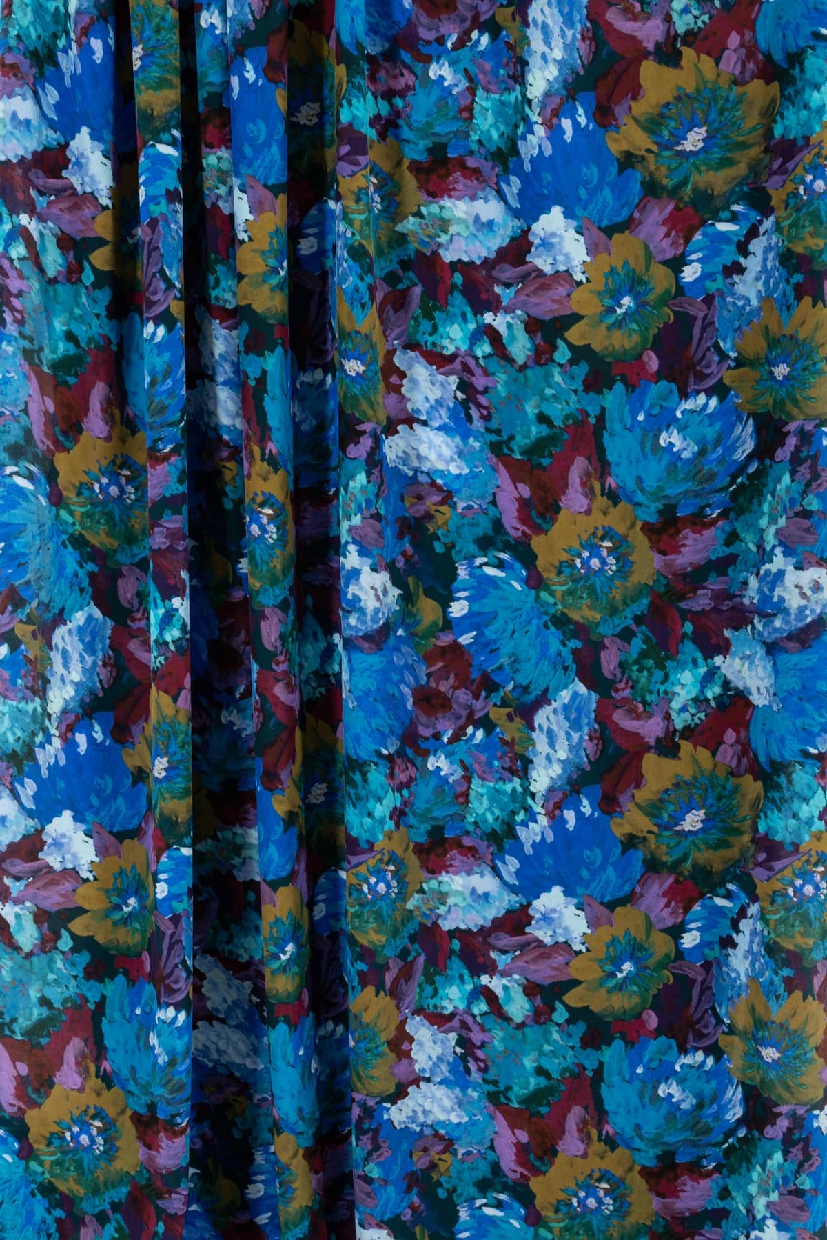 Vibrant floral print fabric in blue, teal, and mustard for apparel sewing projects
