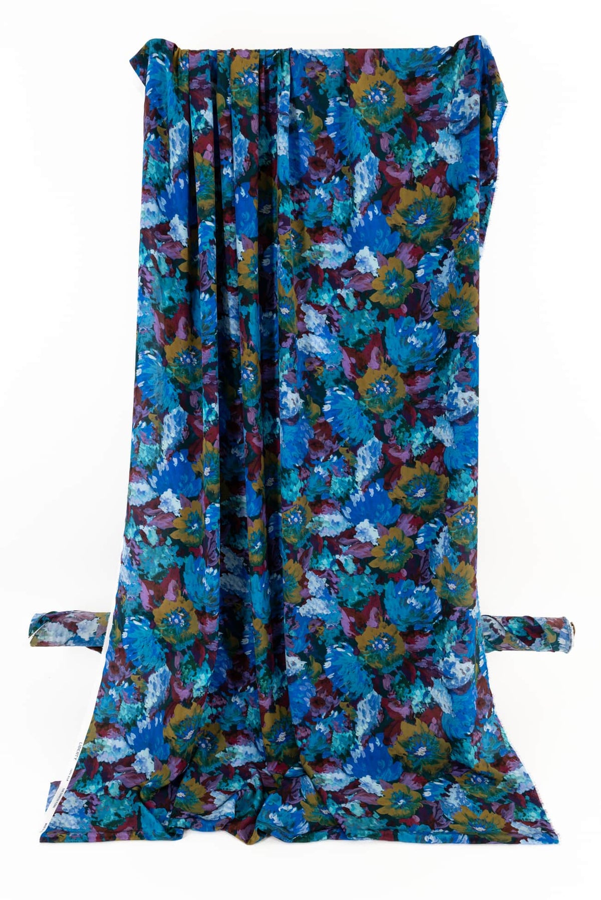 Vibrant floral print fabric in blues, purples, and golds — ideal for apparel sewing and creative projects