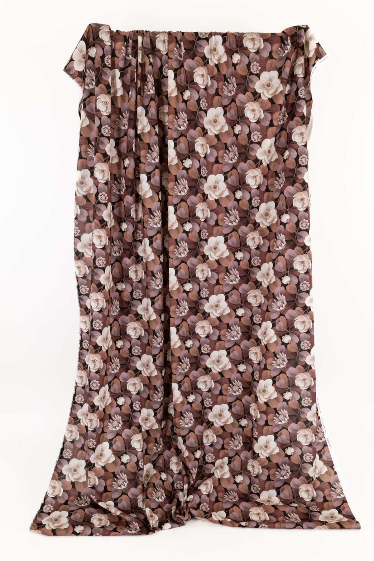 Brown floral print fabric with cream flowers and purple leaves, ideal for apparel sewing projects