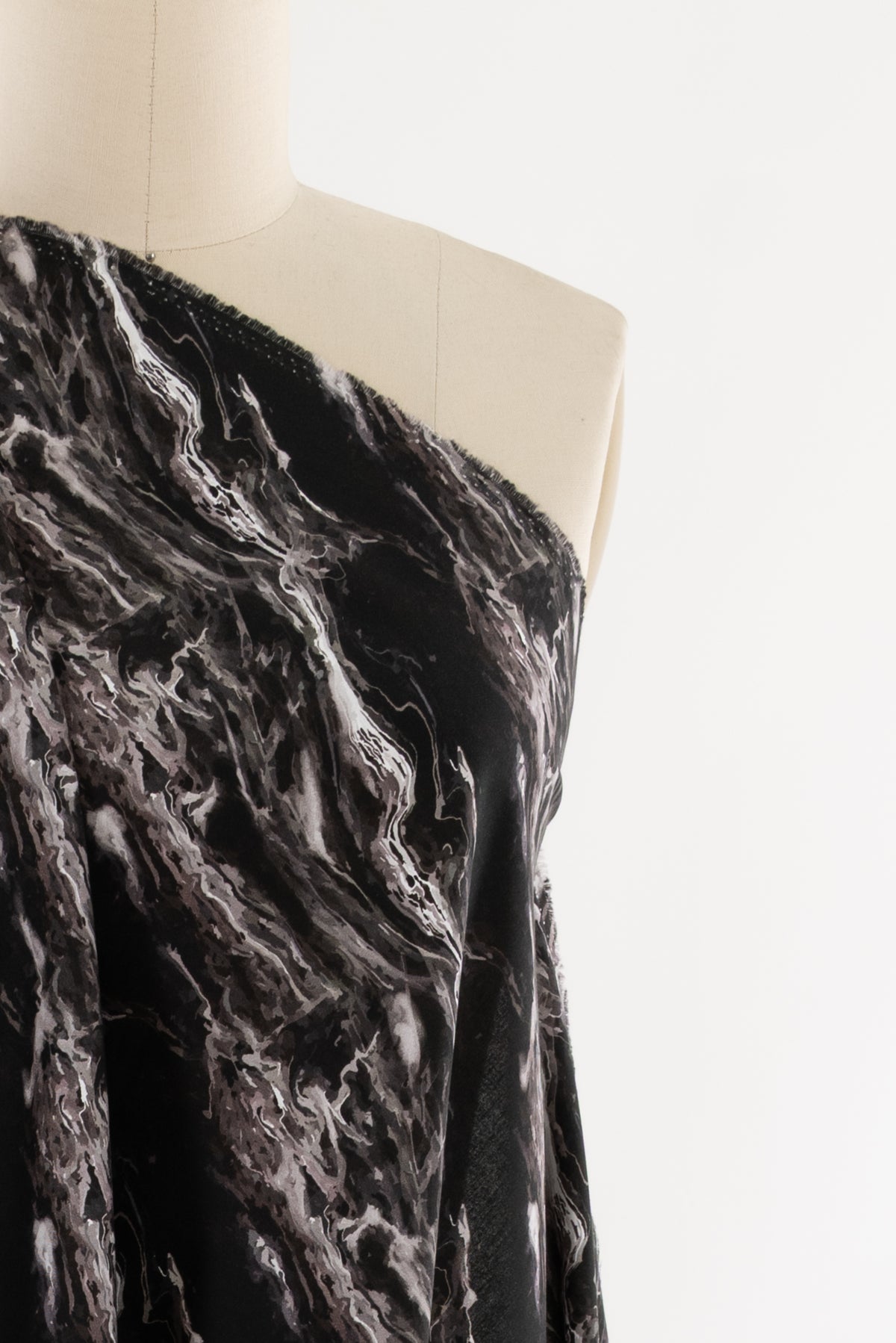 Black and white marble print fabric draped on mannequin, ideal for fashion sewing projects