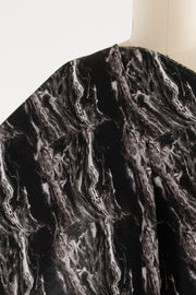 Black and white marble print fabric draped on mannequin, ideal for fashion sewing projects