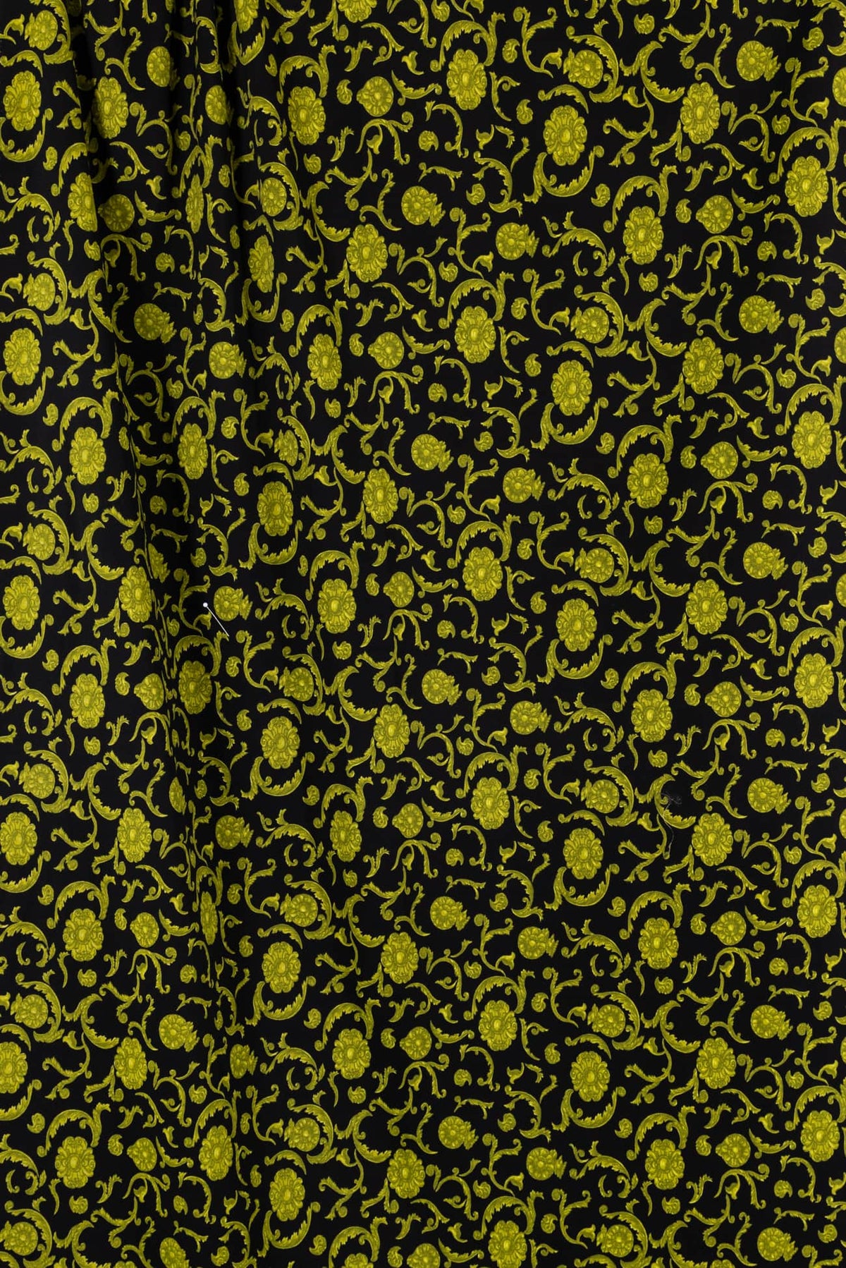 Black fabric with vibrant yellow floral scroll pattern, ideal for apparel and sewing projects