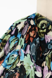Vibrant abstract floral fabric with bold brushstrokes in blue, green, purple, and rust on dark background