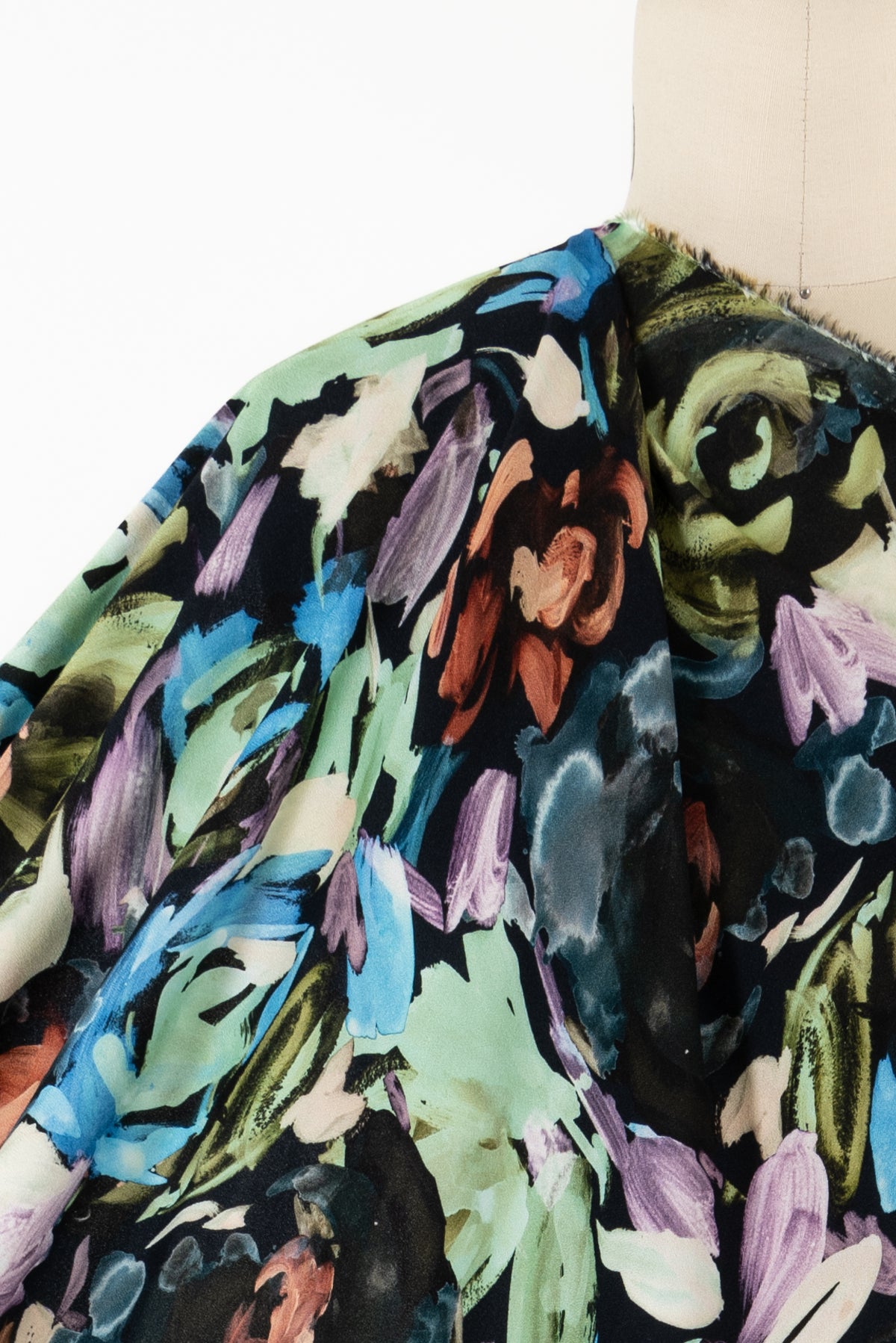 Vibrant abstract floral fabric with bold brushstrokes in blue, green, purple, and rust on dark background